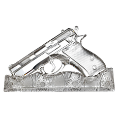 Decorative glass object shaped like a handgun on a white background